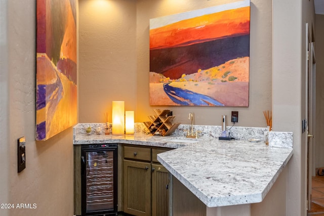 bar featuring tile patterned flooring, light stone counters, sink, and wine cooler