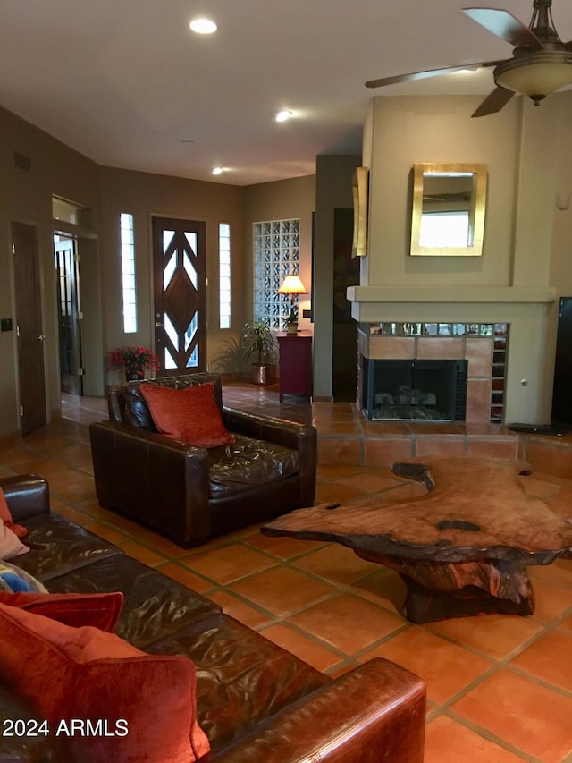 living room with a fireplace, tile patterned flooring, and ceiling fan