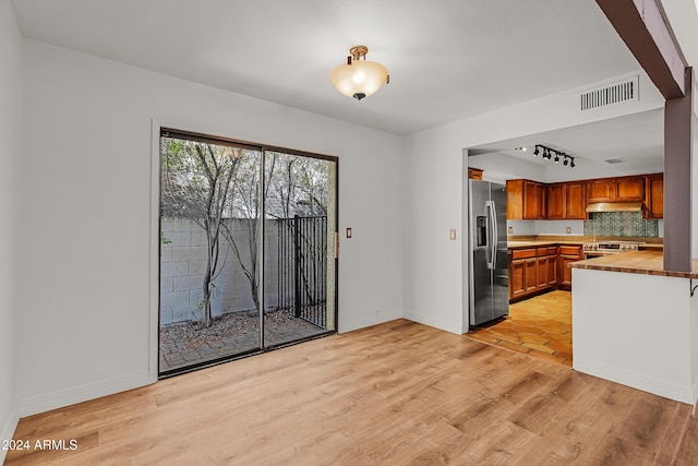 kitchen featuring appliances with stainless steel finishes, light wood-type flooring, tasteful backsplash, and track lighting