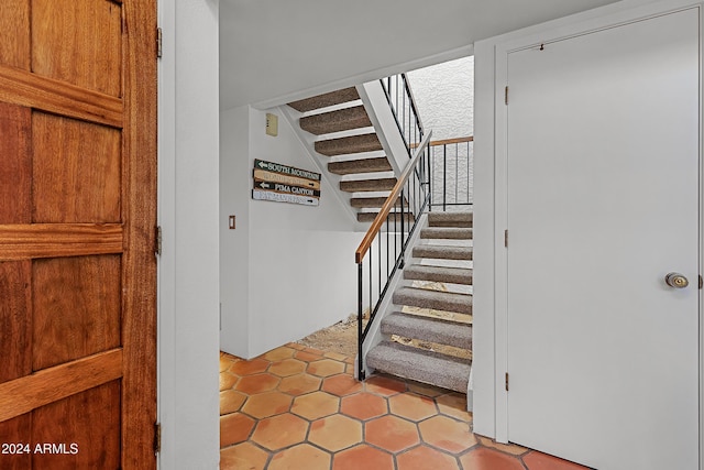 staircase featuring tile patterned flooring