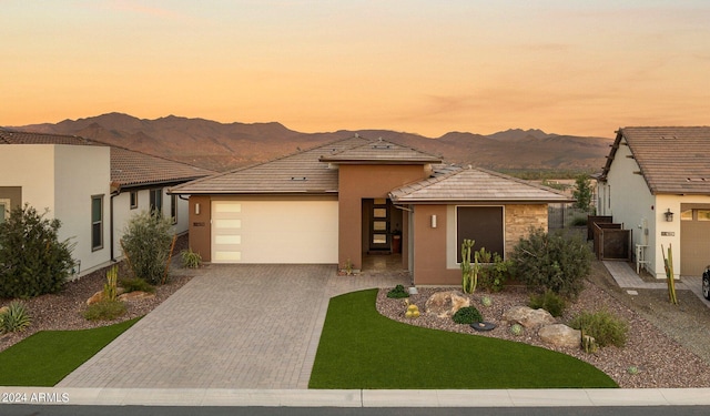 prairie-style house with a mountain view, a garage, and a lawn