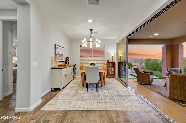 dining area with a notable chandelier and hardwood / wood-style floors