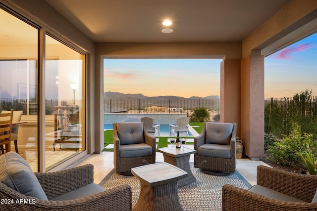 patio terrace at dusk with outdoor lounge area and a mountain view