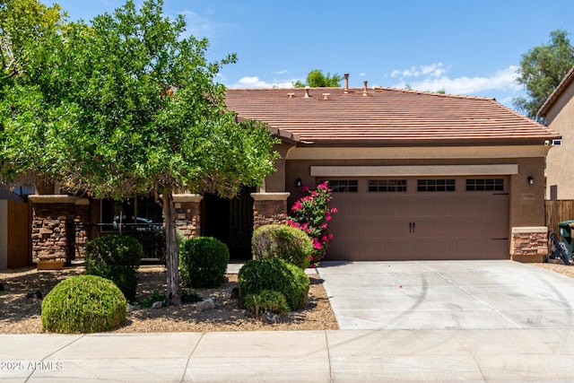 15588 W Devonshire Ave, Goodyear, AZ 85395 - view of front of property with stone siding, concrete driveway, a tiled roof, and an attached garage