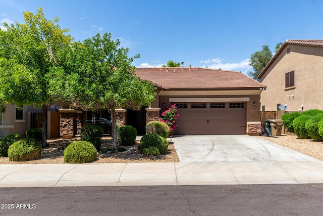 15588 W Devonshire Ave, Goodyear, AZ 85395 - view of front of property featuring a garage, concrete driveway, a tiled roof, stucco siding, and stone siding
