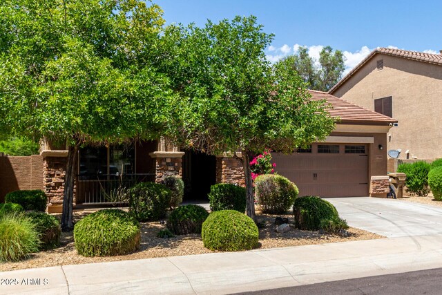 15588 W Devonshire Ave, Goodyear, AZ 85395 - view of front of house with driveway, stucco siding, stone siding, and an attached garage