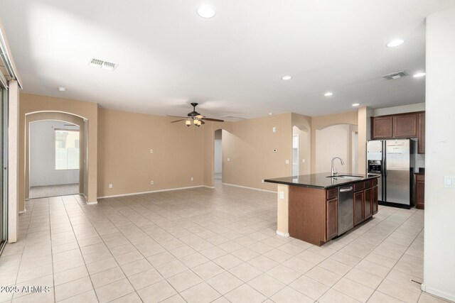 15588 W Devonshire Ave, Goodyear, AZ 85395 - kitchen with stainless steel appliances, arched walkways, dark countertops, and recessed lighting