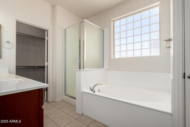 15588 W Devonshire Ave, Goodyear, AZ 85395 - full bathroom with a stall shower, a bath, vanity, tile patterned floors, and a walk in closet