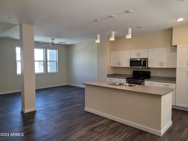 kitchen with appliances with stainless steel finishes, dark wood-type flooring, a sink, and white cabinets