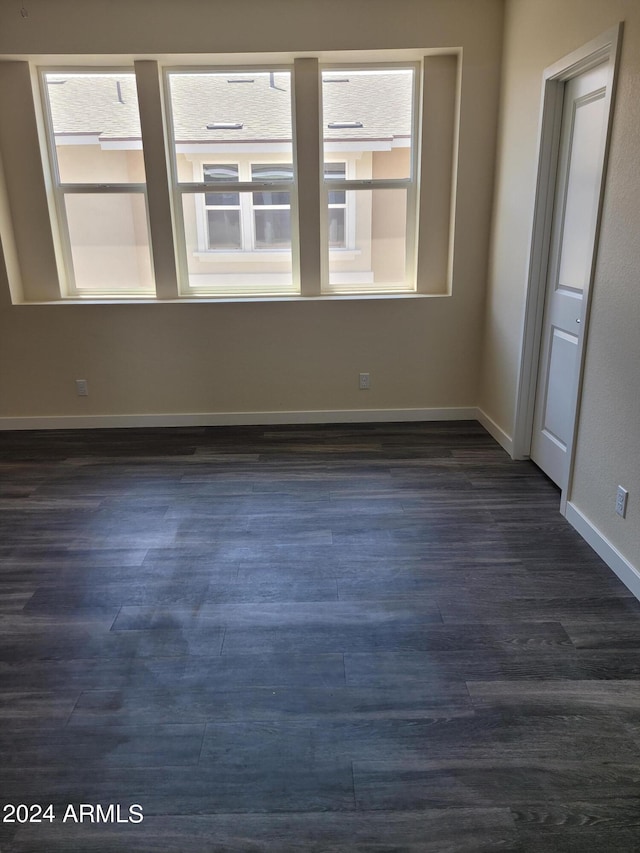 spare room with dark wood-style floors and baseboards