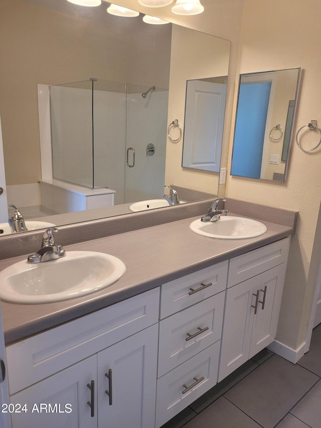 bathroom with a stall shower, a sink, and tile patterned floors