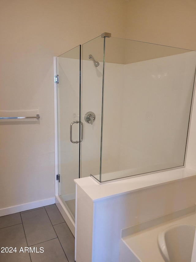 bathroom featuring a stall shower, baseboards, and tile patterned floors