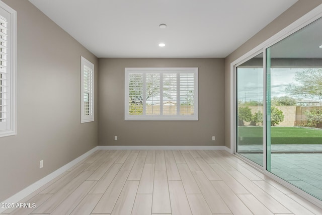 empty room with recessed lighting, baseboards, and light wood-type flooring