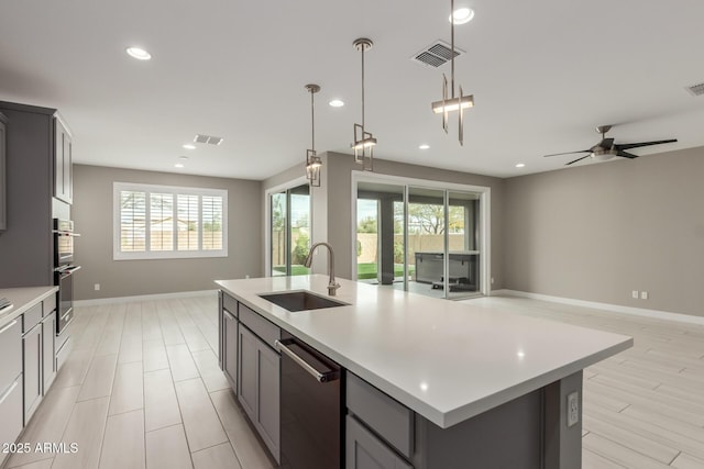 kitchen featuring open floor plan, visible vents, and a sink