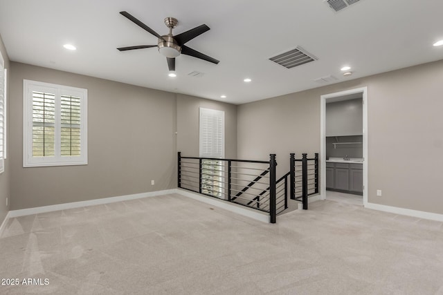 empty room featuring a ceiling fan, recessed lighting, light colored carpet, and visible vents