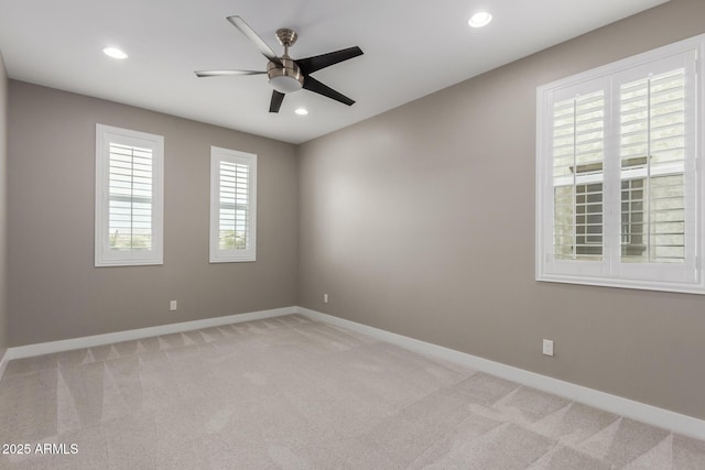 empty room featuring light carpet, recessed lighting, baseboards, and ceiling fan