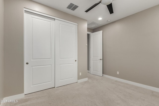 unfurnished bedroom featuring a ceiling fan, baseboards, visible vents, a closet, and light carpet