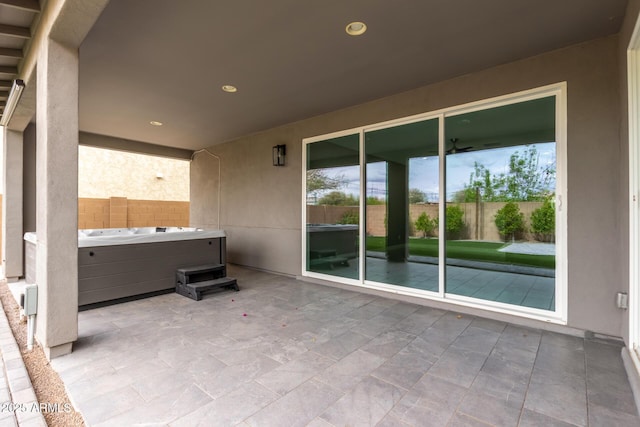 view of patio featuring fence and a hot tub