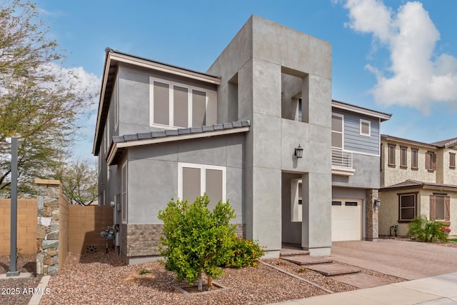 view of front of house with stucco siding, concrete driveway, and a garage