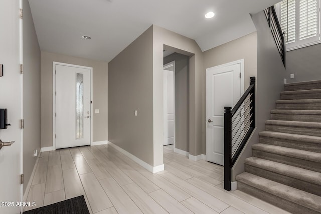 foyer entrance featuring recessed lighting, baseboards, wood tiled floor, and stairs