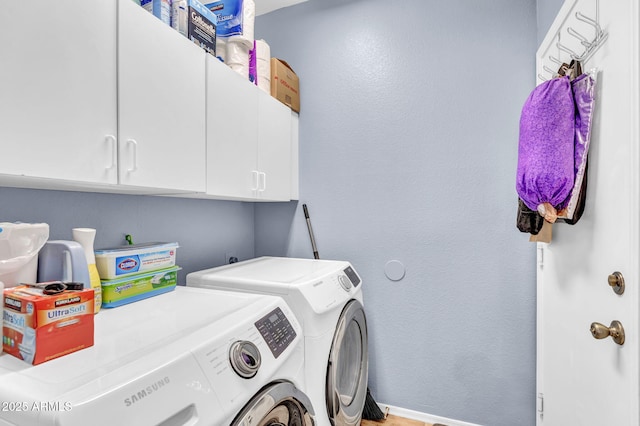 clothes washing area with separate washer and dryer, cabinet space, and baseboards