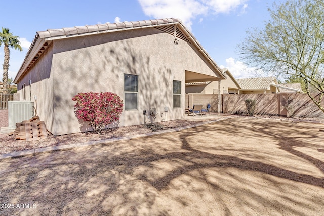 back of house featuring a patio, cooling unit, fence, and stucco siding