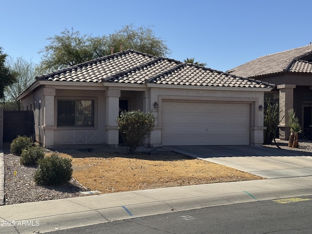 view of front of house featuring a garage, concrete driveway, a tile roof, and stucco siding