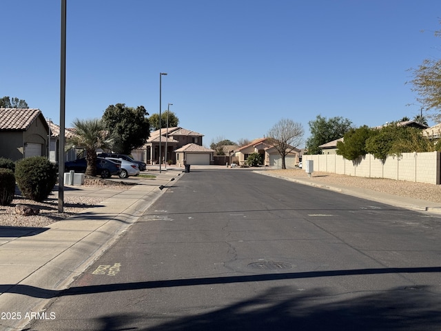 view of street featuring sidewalks, street lights, a residential view, and curbs