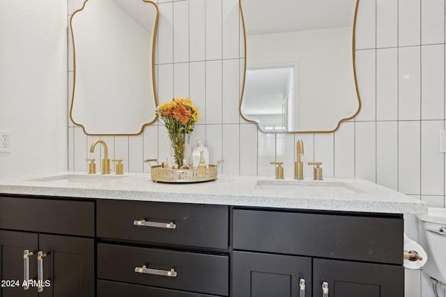 bathroom featuring vanity, toilet, and backsplash