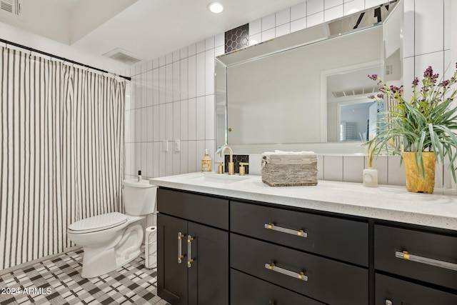 bathroom featuring walk in shower, tile patterned floors, toilet, vanity, and tile walls