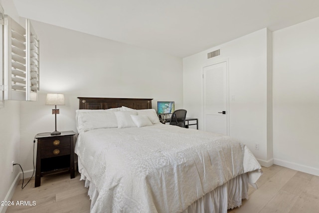 bedroom with light hardwood / wood-style flooring and a closet