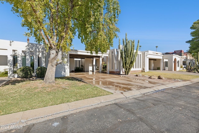 view of front of house with a front lawn and a carport