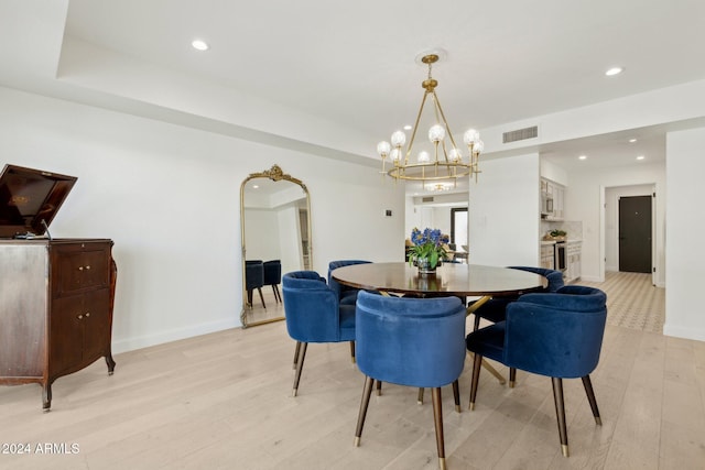 dining room with a chandelier and light hardwood / wood-style flooring