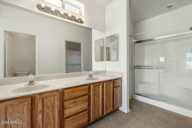 bathroom featuring vanity, toilet, and an enclosed shower