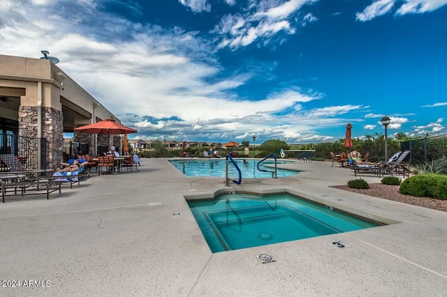 view of swimming pool featuring a patio area and a hot tub