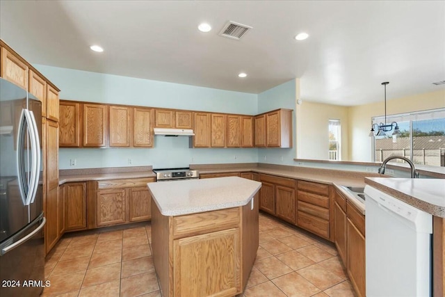 kitchen with sink, a kitchen island, pendant lighting, and appliances with stainless steel finishes