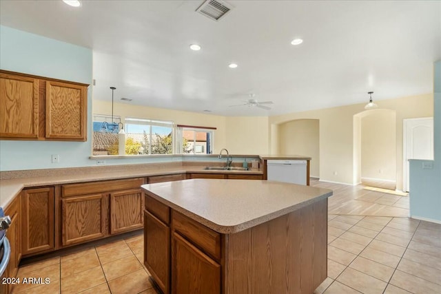 kitchen featuring white dishwasher, ceiling fan, sink, decorative light fixtures, and a kitchen island