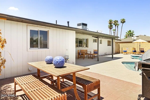 rear view of property featuring a patio and a fenced in pool