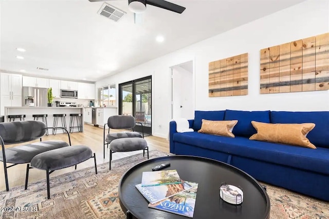 living room with light wood-type flooring and ceiling fan