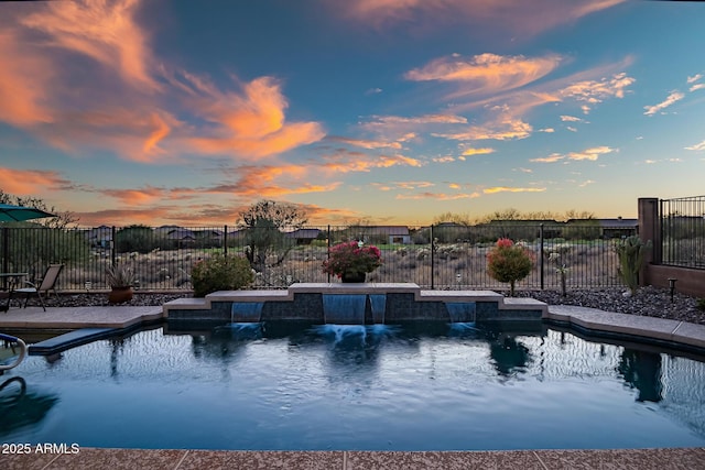 pool at dusk with fence and a fenced in pool