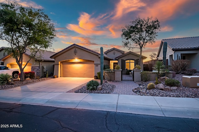 view of front of property featuring a fenced front yard, an attached garage, driveway, a gate, and stucco siding