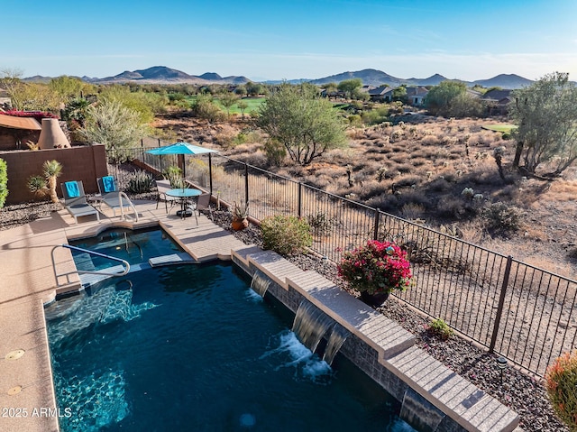 view of pool with a patio, a pool with connected hot tub, fence private yard, and a mountain view