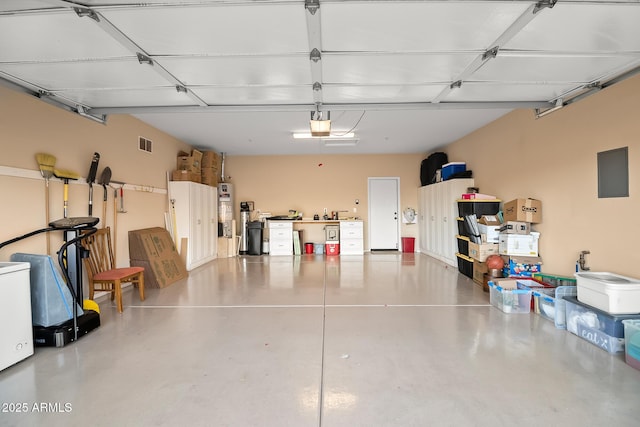 garage with water heater, visible vents, and a garage door opener