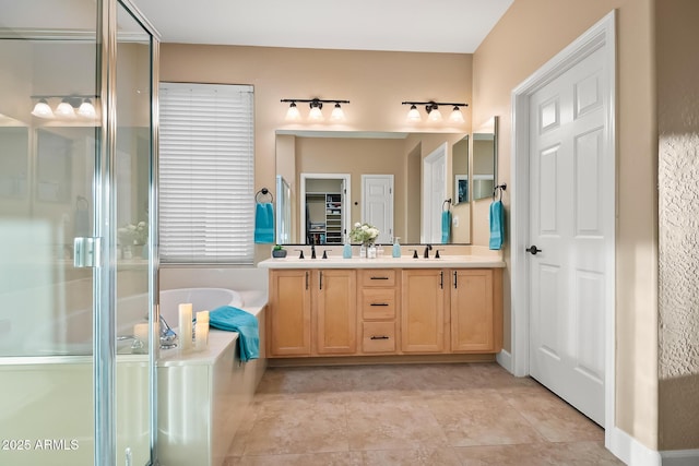 full bathroom with double vanity, a garden tub, a sink, and a stall shower