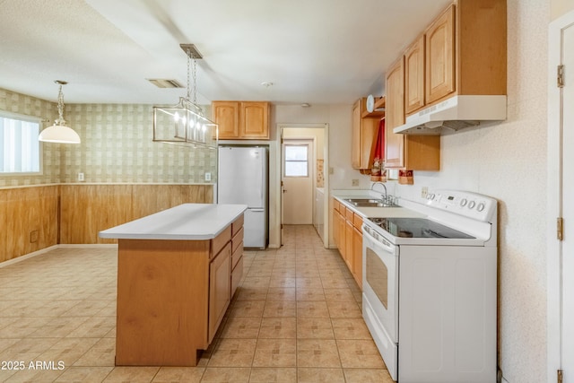 kitchen featuring white appliances, wallpapered walls, wainscoting, under cabinet range hood, and a sink