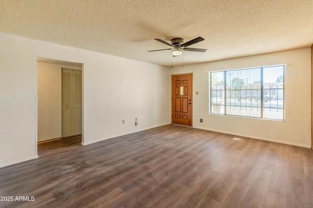 spare room featuring a textured ceiling and dark wood finished floors