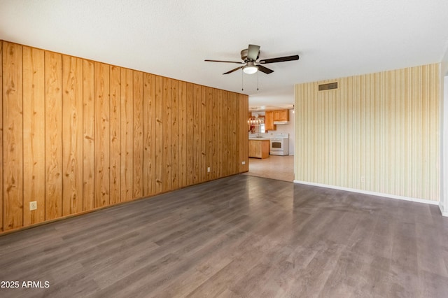 unfurnished living room with baseboards, ceiling fan, visible vents, and wood finished floors