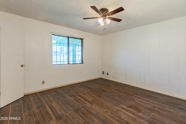 spare room with dark wood-type flooring, a textured ceiling, and a ceiling fan