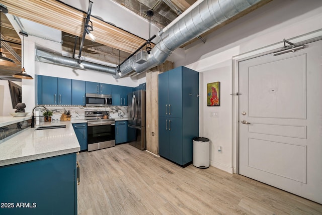 114 W Adams St Unit 202, Phoenix, AZ 85003 - kitchen featuring blue cabinetry, appliances with stainless steel finishes, light wood-style flooring, tasteful backsplash, and light stone countertops