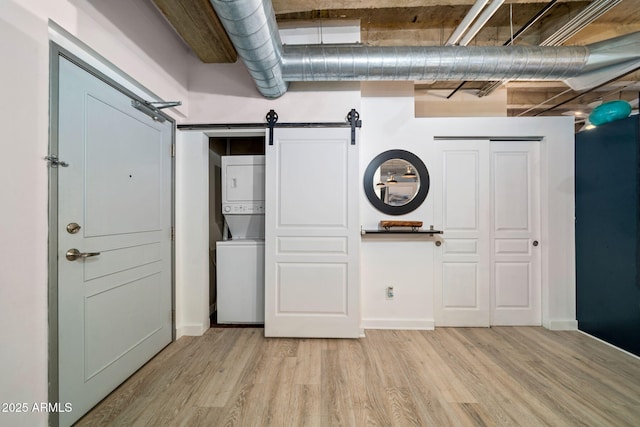 114 W Adams St Unit 202, Phoenix, AZ 85003 - laundry room with stacked washer / dryer, a barn door, and wood finished floors